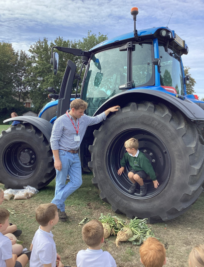 The children chat to Farmer Simon and look at the tractor